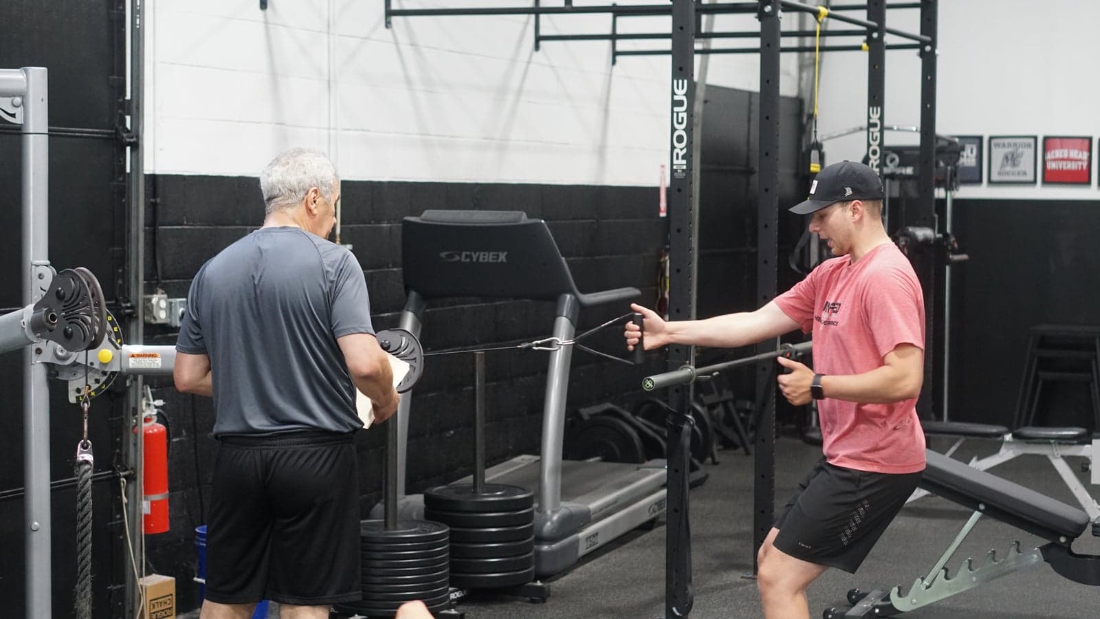 A coach walks a client through a cable rotation drill