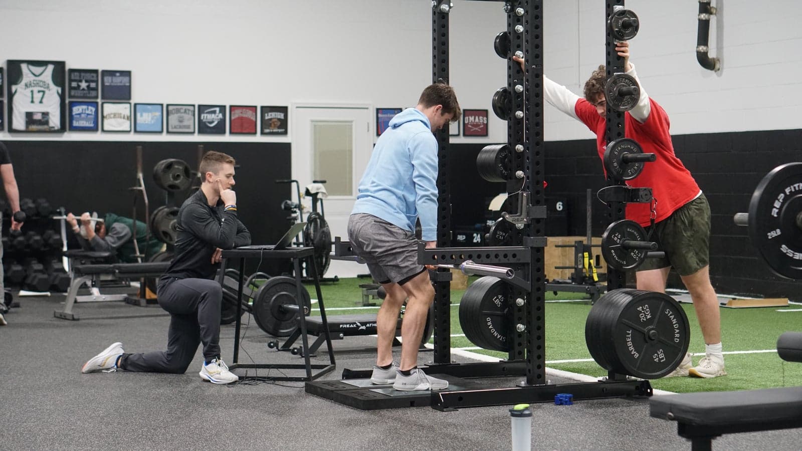 A coach watches an athlete's movement screen on a laptop at Unified Health & Performance