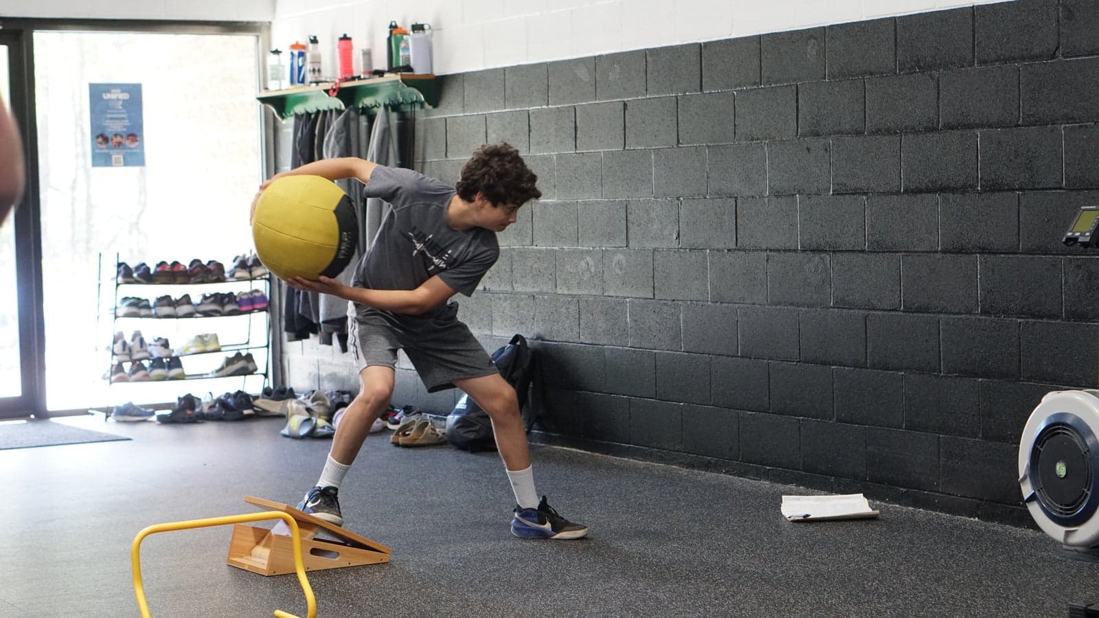 A junior athlete loads a medicine ball for a rotational throw