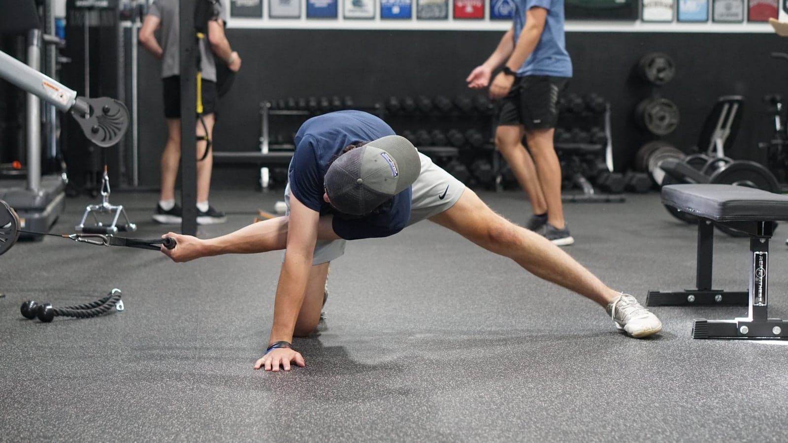 An athlete holds a deep lateral lunge with a cable reach